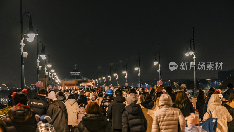 夜晚人群在路灯下的热闹场景