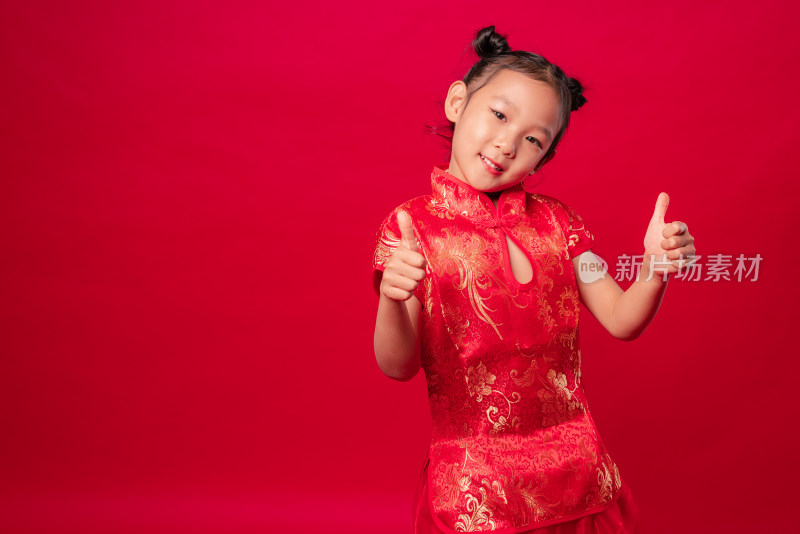 红色背景前穿旗袍竖大拇指的中国女孩