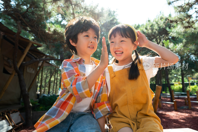 两个小孩子开心击掌庆祝