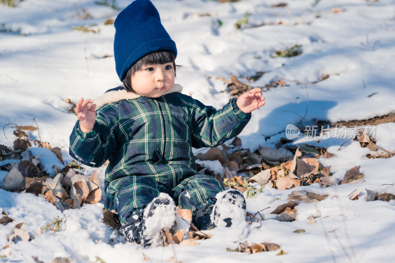 中国北京坐在公园雪地里的女童