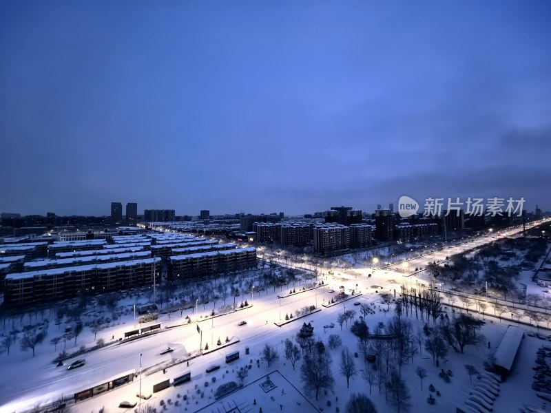 暮色下被雪覆盖的城市建筑群