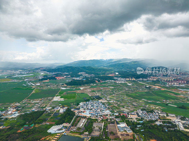 航拍乌云暴雨下的勐海县田园风光