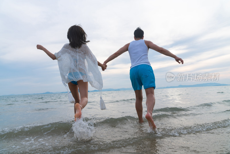 快乐的年轻情侣在海边玩耍