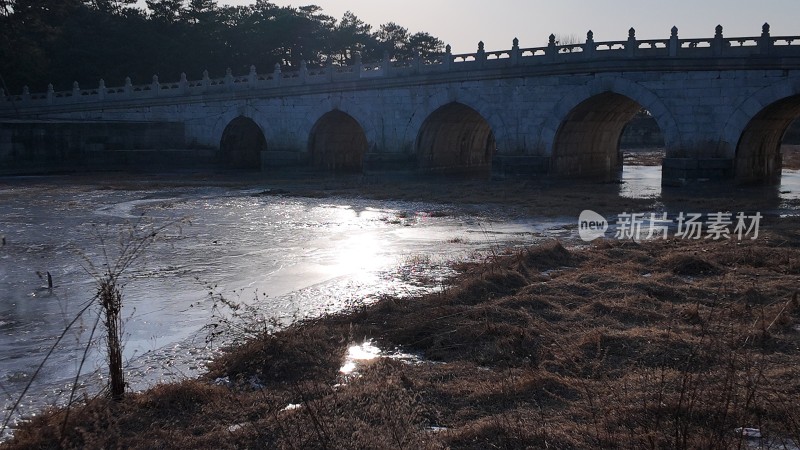 清西陵石桥横跨水面周围草木萧疏的景象