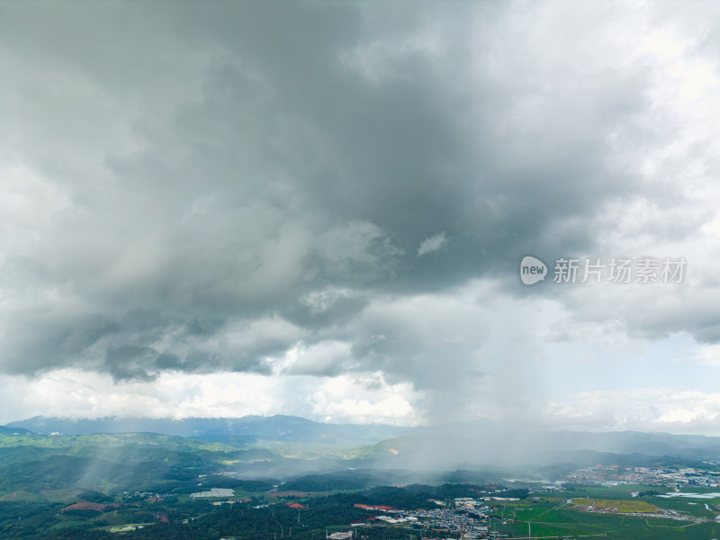 航拍乌云暴雨下的勐海县田园风光