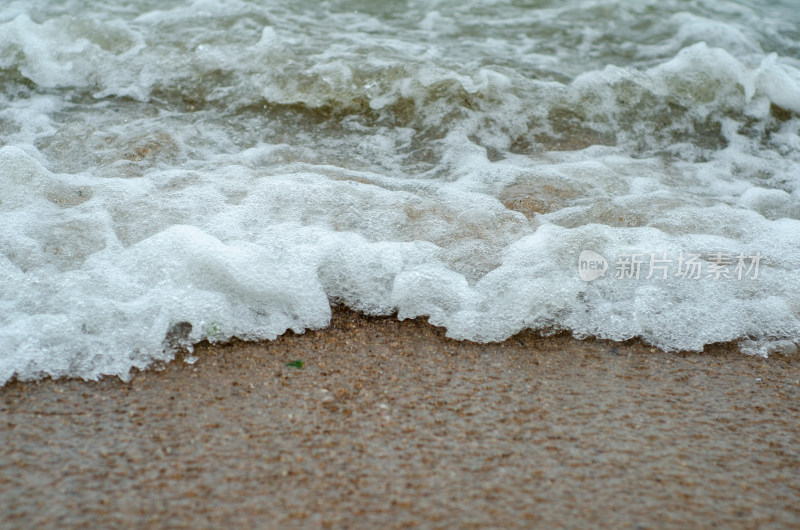 冲向沙滩的白色泡沫