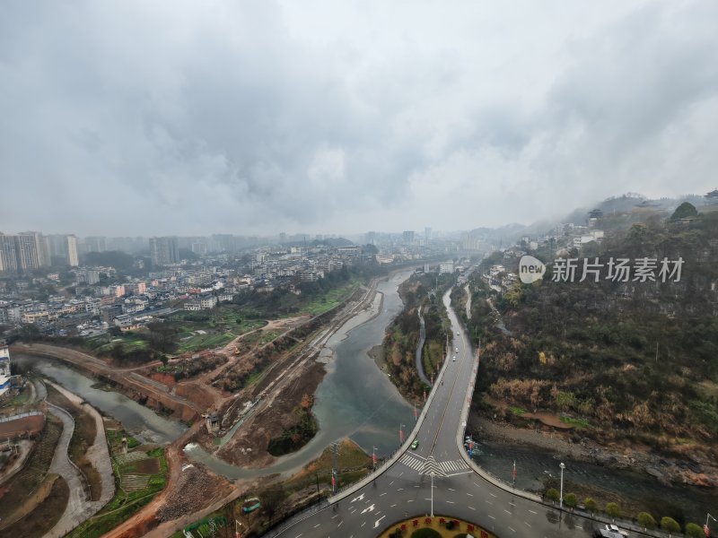 阴云笼罩下的城市道路与河流鸟瞰图