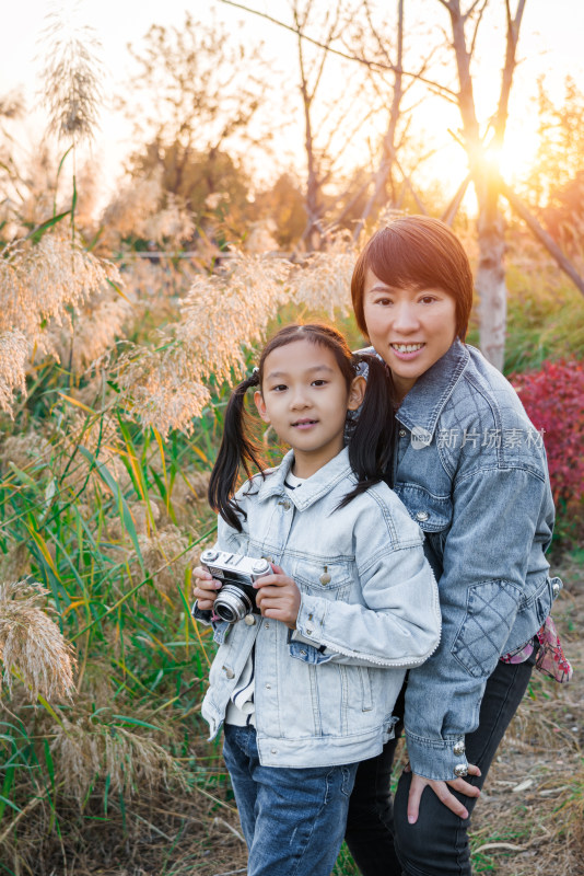 秋天在公园花丛中游玩中国母女肖像