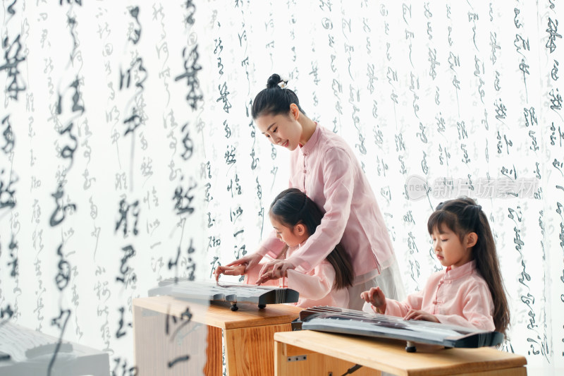 青年老师教小学生学古筝