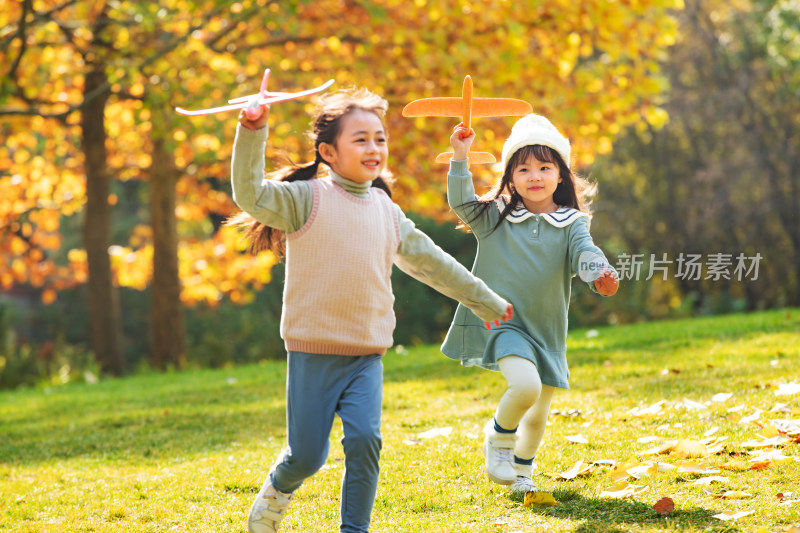 拿着玩具飞机在公园玩耍的女孩