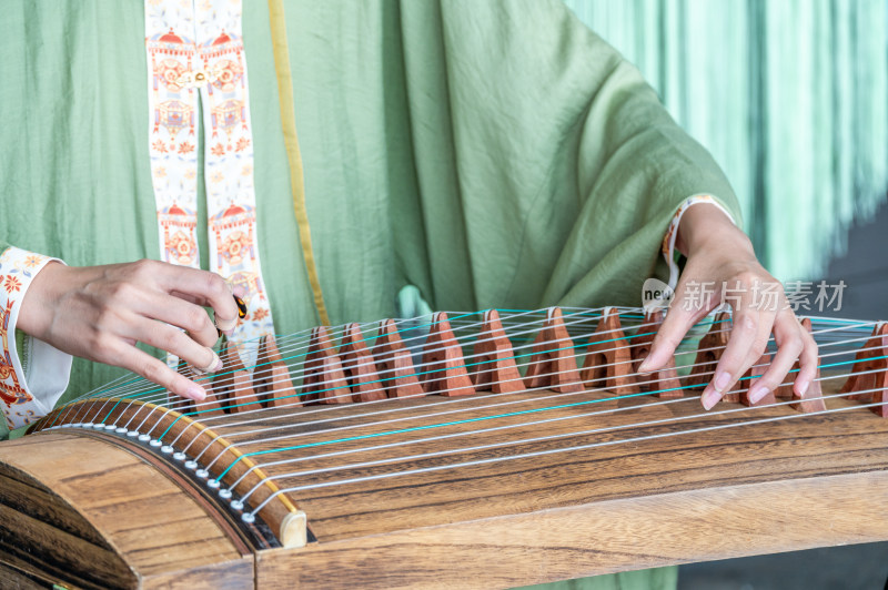 一位身穿中国传统汉服的女子弹奏古筝唯美