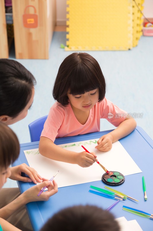 幼儿园女老师辅导儿童画画