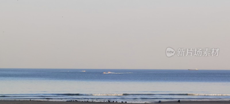 海岸边平静的海面与行驶船只