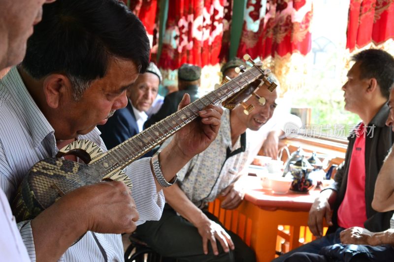 男子演奏民族乐器众人围坐