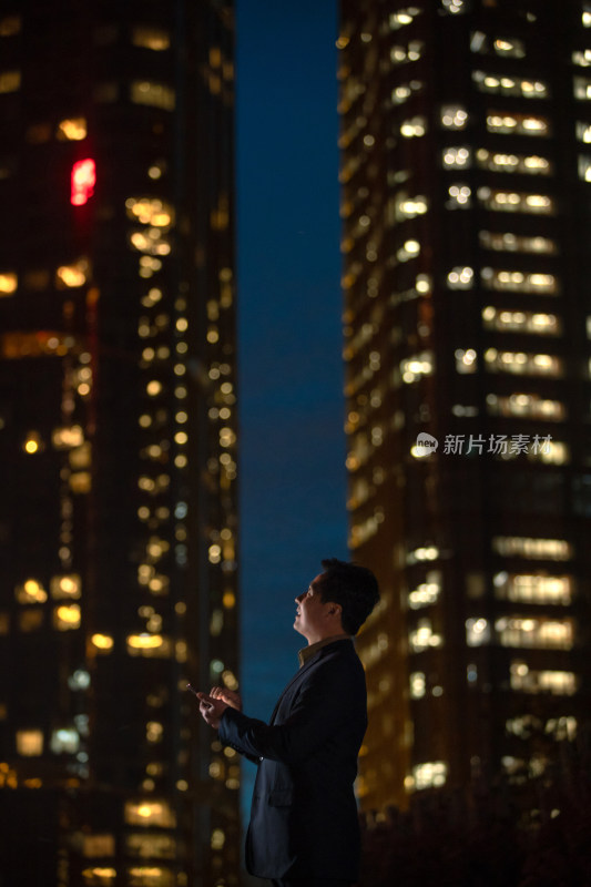 晚上在户外看手机的商务男士