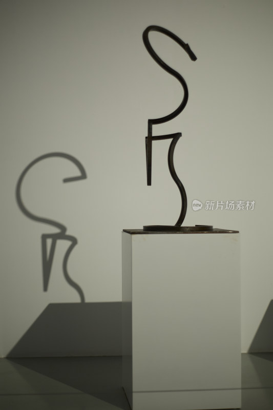 白色底座上的黑色抽象雕塑