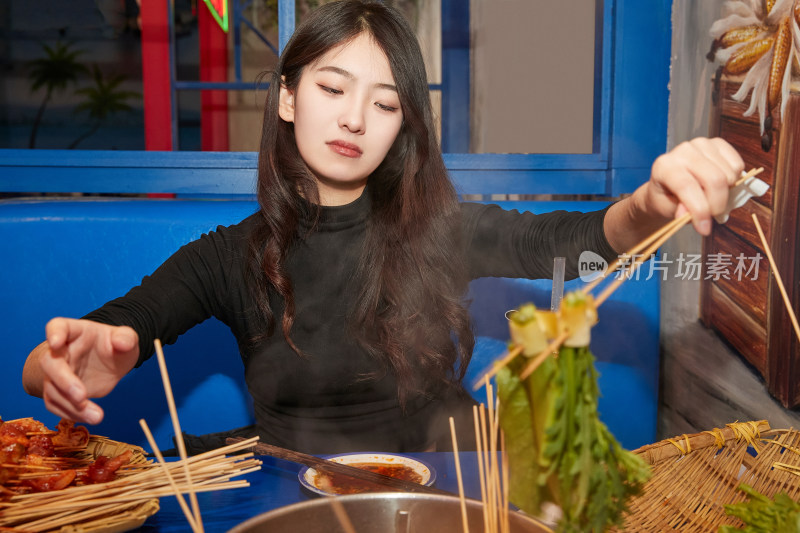 在饭馆吃成都串串的亚洲少女