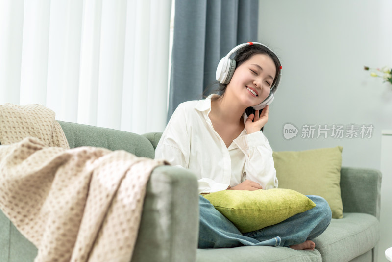 年轻女性在卧室听音乐
