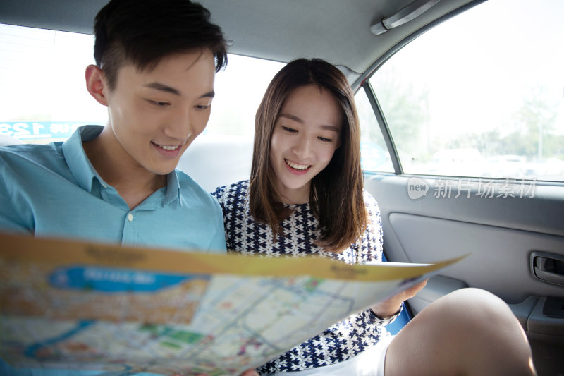 青年情侣在车内看地图