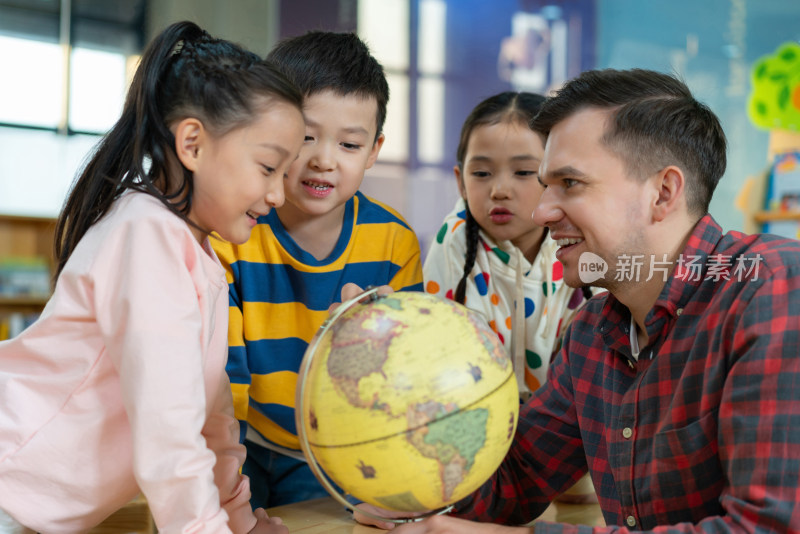 外籍老师教孩子辨认地球仪
