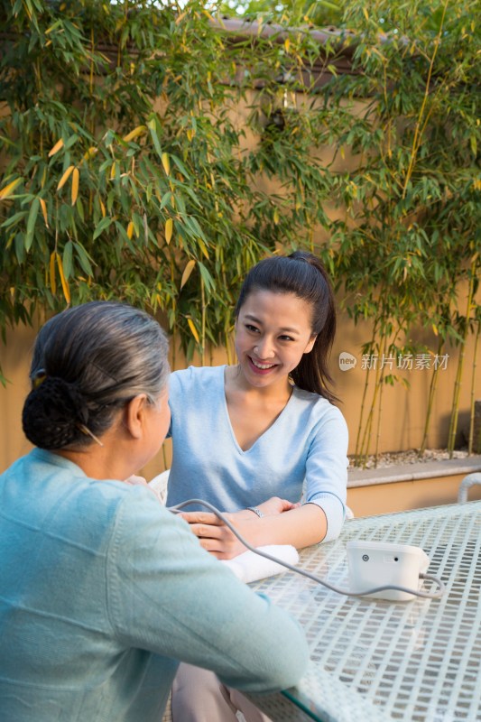 年轻女人给老年女人量血压