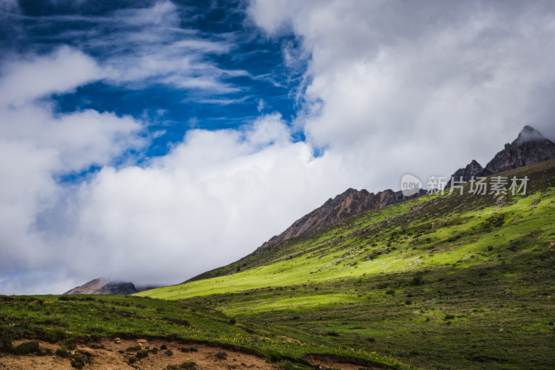 蓝天白云下广袤草原与连绵山峦自然风景