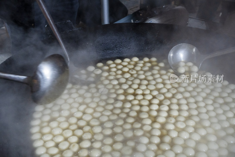 大锅中煮着大量白色汤圆