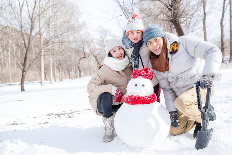 一家三口在雪地里堆雪人