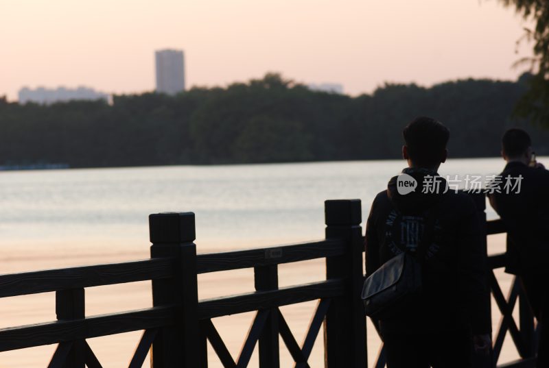 湖畔两人倚栏赏景