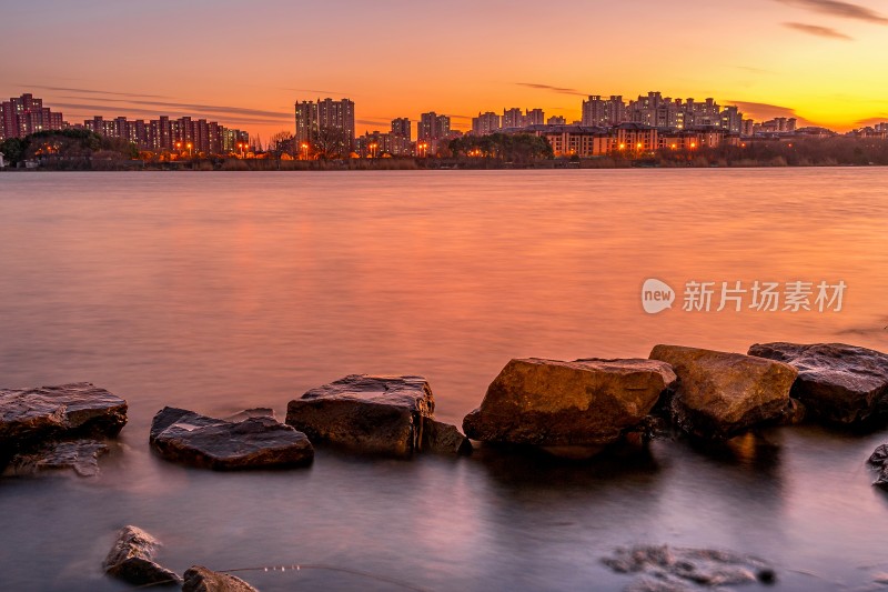 湖边日落景象，芦苇岩石相伴