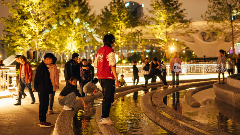 成都交子公园跨越锦江的莲叶景观桥夜晚市民