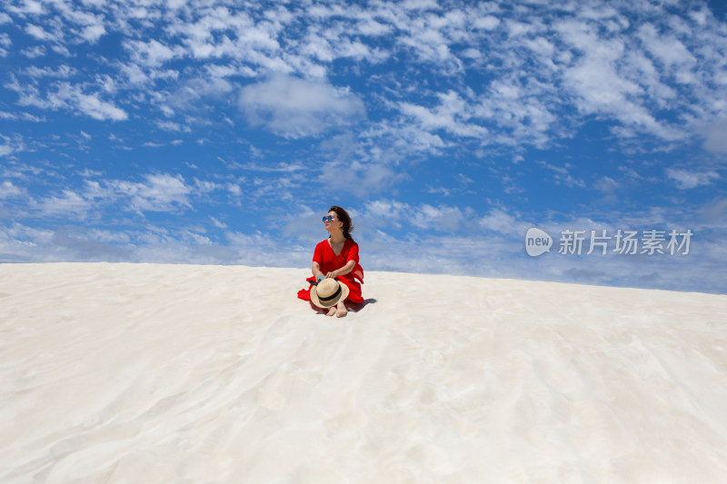 坐在一望无际白沙漠上的女人