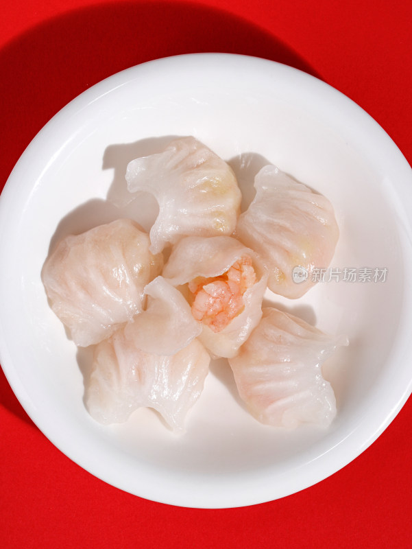 红色桌面上的一盘子广东早茶虾饺