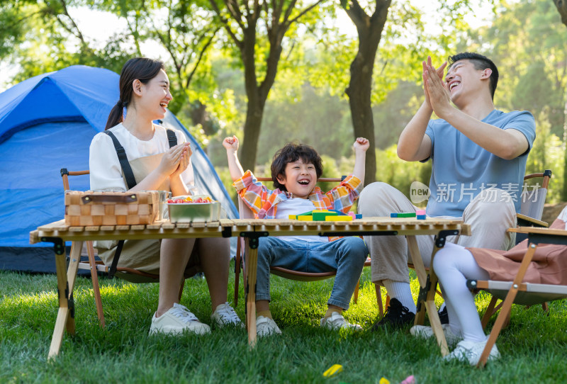 一家四口在露营地玩游戏开心欢呼庆祝