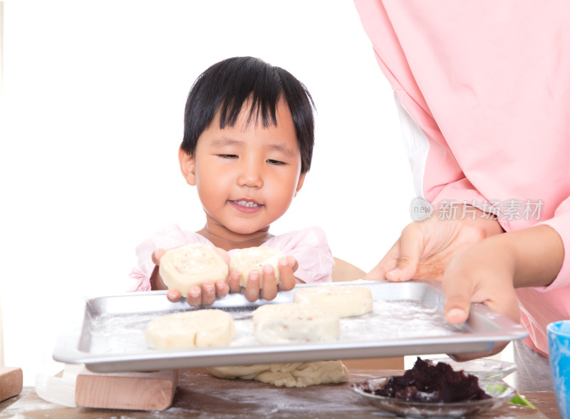 中国小女孩把做好的月饼放在烤盘里