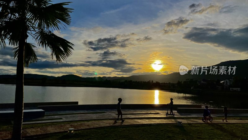 湖畔夕阳下人们休闲活动场景