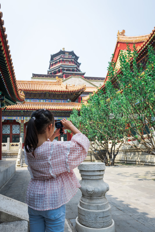 在北京颐和园万寿山佛香阁下游览拍照的女孩