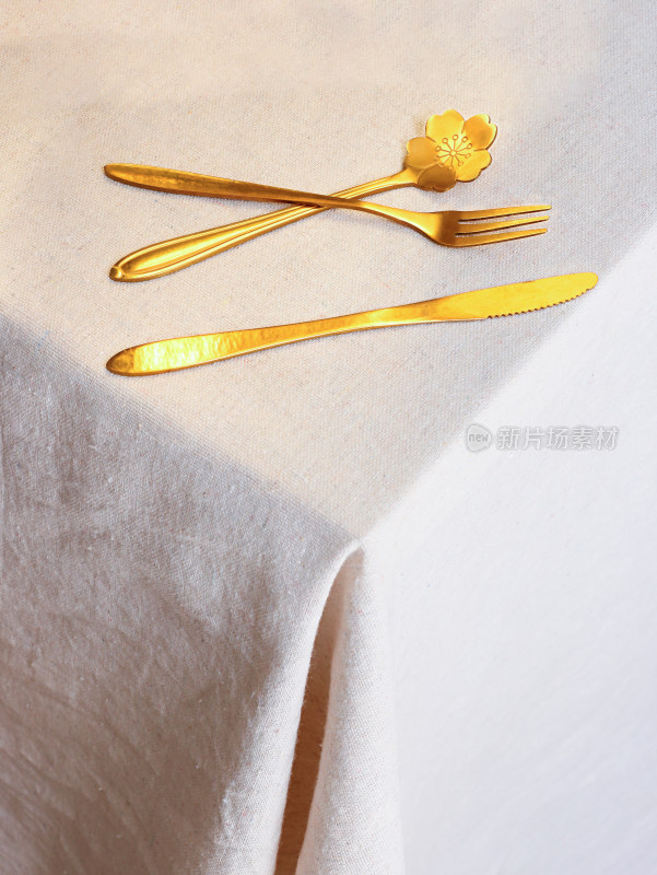 白色桌面上摆放着的西餐餐具刀叉
