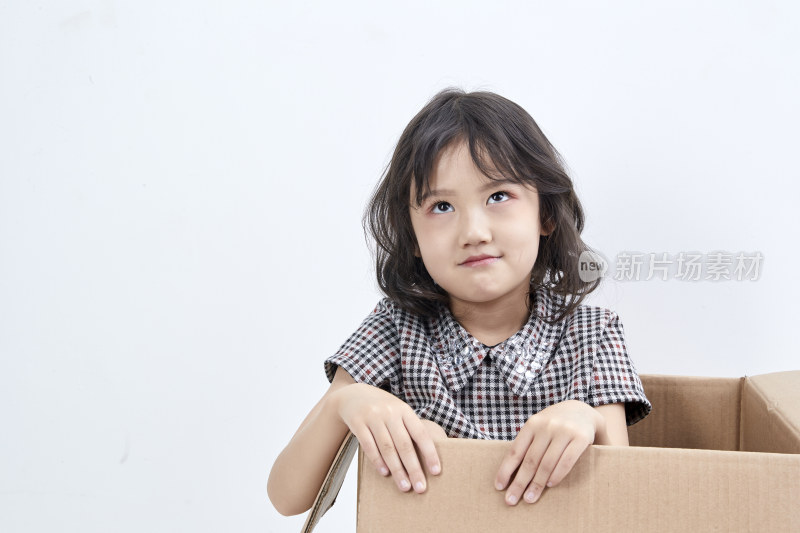 躲在纸箱中玩耍的调皮可爱亚洲小女孩（儿童）