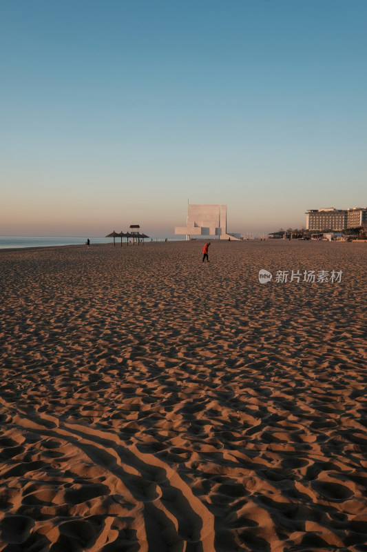 沙滩上有人漫步的海边景象