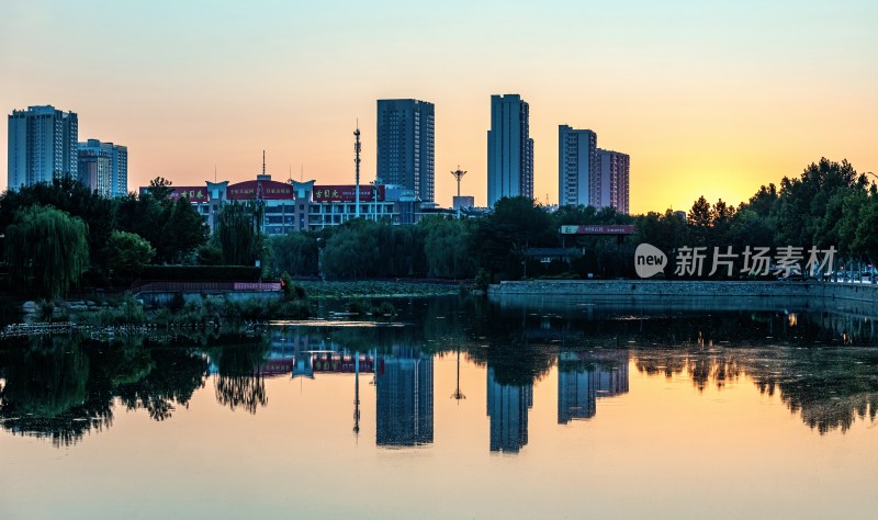 德州龙运湖城市湖畔夕阳下的高楼倒影