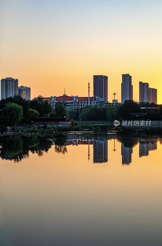 德州龙运湖城市湖畔夕阳下的高楼倒影