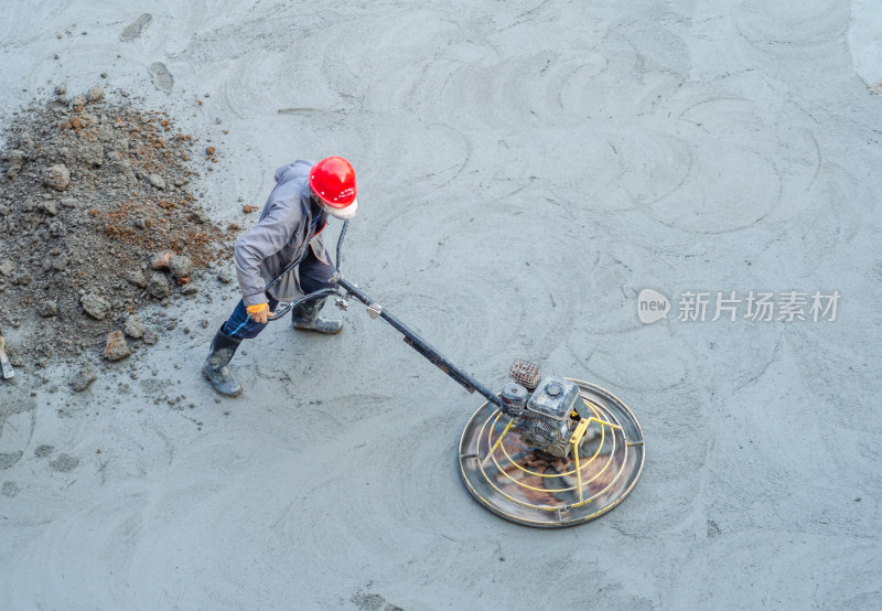 建筑工地上，工人正使用路面抹平机平整路面