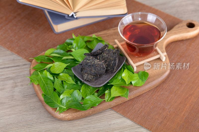 砧板上的茶水和茶叶和铺着的绿叶