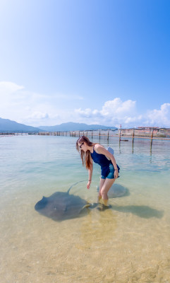 海南三亚中国亚裔美女向蔚蓝色海边奔跑