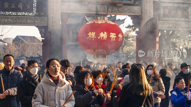 寺庙前戴口罩的人群手持香祈福场景