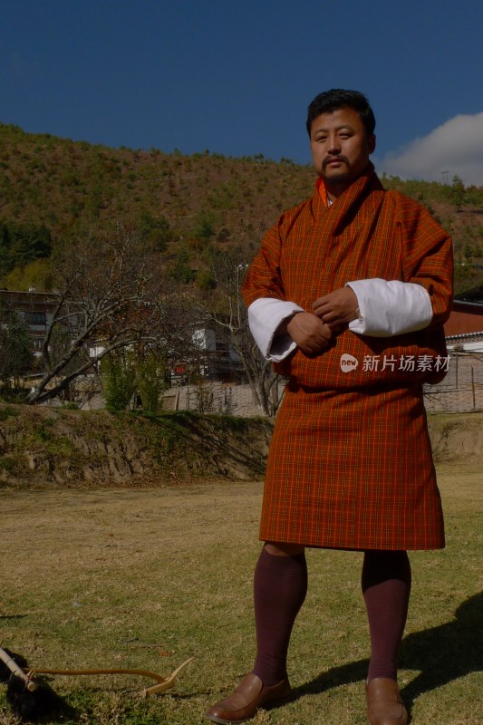 身着传统服饰的男子户外站立姿态