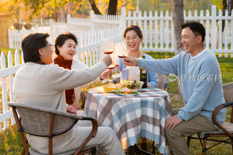 夕阳下中老年朋友在庭院里聚会喝酒聊天