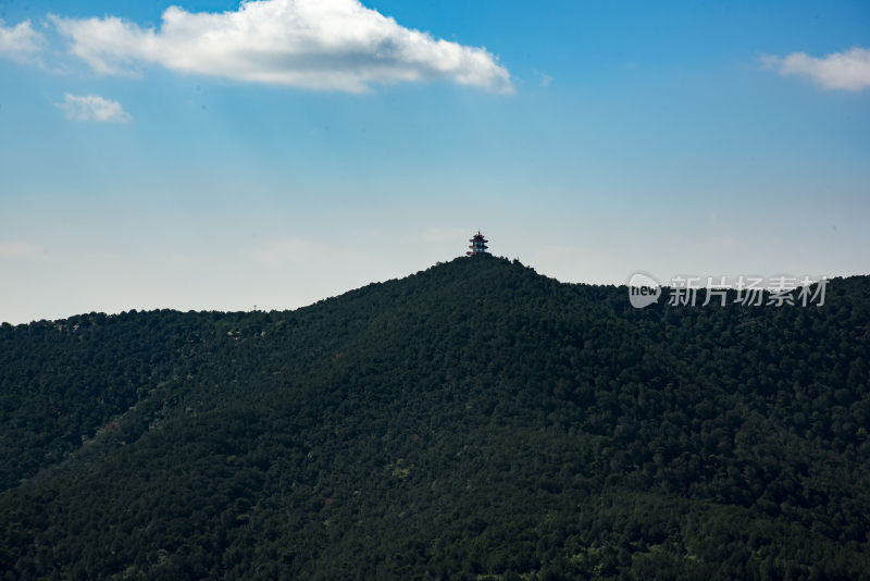 青山之上矗立塔楼的远景自然风光