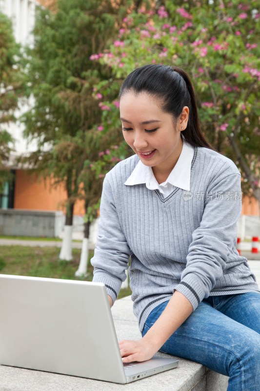 年轻大学生在校园里使用笔记本电脑